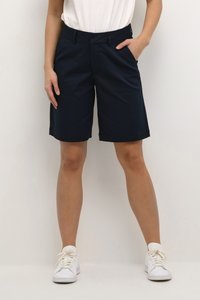 Navy blue shorts made of a flexible fabric, featuring a classic cut with side pockets and a clean hem. Paired with white sneakers.