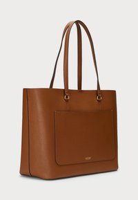 Bolsa tote de couro castanho com uma textura suave, duas alças para ombro e um bolso na frente. Apresenta uma marcação discreta e linhas limpas.