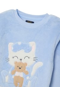 Sweat-shirt en peluche bleu clair avec un motif brodé d'un chat souriant portant un masque de sommeil, tenant un ours en peluche marron.