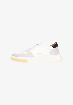 White and gray sneaker with suede and leather textures, featuring a round toe, lace-up design, and a cream rubber sole. Gold logo accent.