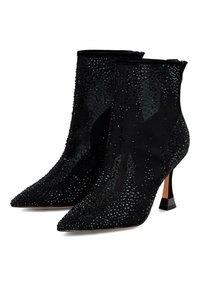 Cizme negre cu vârf ascuțit, până la gleznă, cu toc înalt și subțire, acoperite cu mici strasuri strălucitoare pe suprafață și pe laturi.