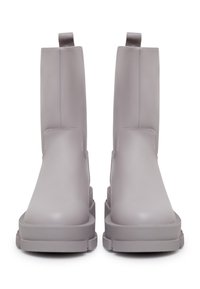 Botines de cuero gris con una superficie suave, suela de goma plana y tiradores en el collar para facilitar su uso. Diseño minimalista.