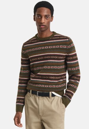 Gebreid sweater in donkergroen met meerkleurige horizontale strepen en patronen. Heeft een ronde hals en ribbelmanchetten. Gecombineerd met kaki broek.