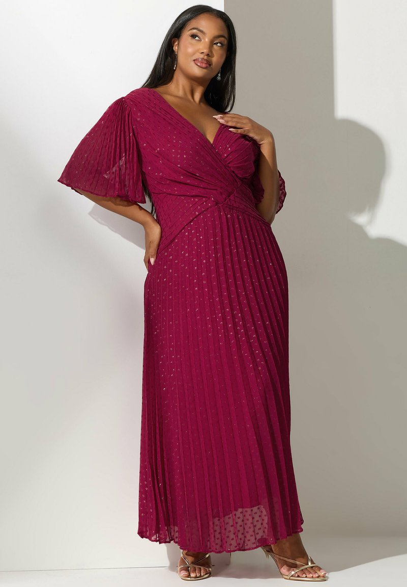 Largo vestido plisado en burdeos profundo. Escote en V con bodice envuelto y mangas con vuelo. Tejido ligero y texturizado con patrones sutiles.