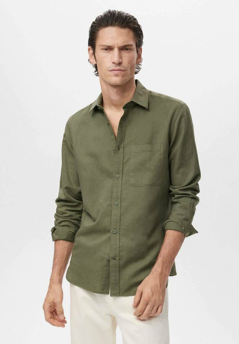 Camisa de lino verde oliva con cuello abotonado, mangas largas arremangadas en los puños y un bolsillo en el pecho.