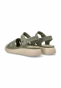 Sandalias de tela verde con un diseño de malla, correas cruzadas ajustables y una suela acolchada beige. Detalles texturizados en las correas.