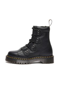 Zwarte leren enkelboots met een gestructureerde afwerking, drie paar oogjes en gele stiksels op een dikke zool. Beschikt over een lussenband op de hak.