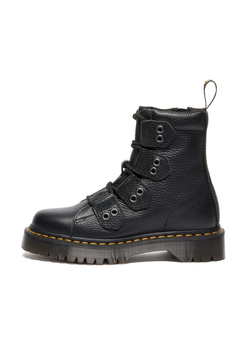 Zwarte leren enkelboots met een gestructureerde afwerking, drie paar oogjes en gele stiksels op een dikke zool. Beschikt over een lussenband op de hak.