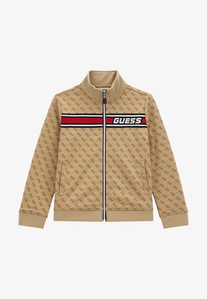 Veste beige zippée avec motif logo ton sur ton, col montant, bande horizontale noire et rouge avec le texte 'GUESS' sur la poitrine, poches latérales.