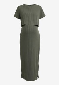 Robe midi côtelée vert olive avec des manches courtes, un haut court et une fente sur le côté. Fabriquée dans un tissu doux, mettant en valeur une silhouette ajustée.