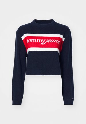 Mornarica skraćeni pulover s dugim rukavima, s crvenom i bijelom horizontalnom prugom i tekstom "tommy jeans" u kurzivnom fontu. Mekana tekstura.