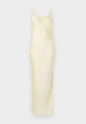 Saténové žlté šaty s rovnou siluetou, tenkými ramienkami a bočným rozparkom pre pohodlie pri pohybe. Hladká textúra a minimalistický dizajn.
