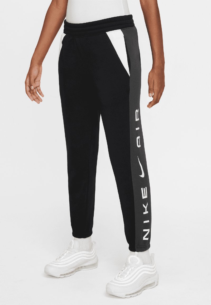 Black jogger pants with white accents, Nike Air branding, elastic waistband, and tapered ankle fit. Made from soft, breathable material.