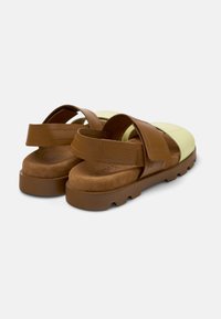 Brown and light green sandals with two adjustable straps, soft suede inner lining, and thick rubber sole featuring a textured grip.
