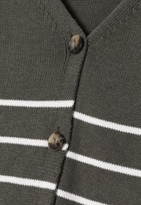 Ciemnoszary dzianinowy materiał w poziome białe paski oraz dwa ciemne marmurkowe guziki na zapięciu kardiganu.