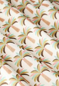 Tissu présentant un motif répétitif de palmiers avec des troncs marron, des fronds verts et roses, sur un fond crème clair.