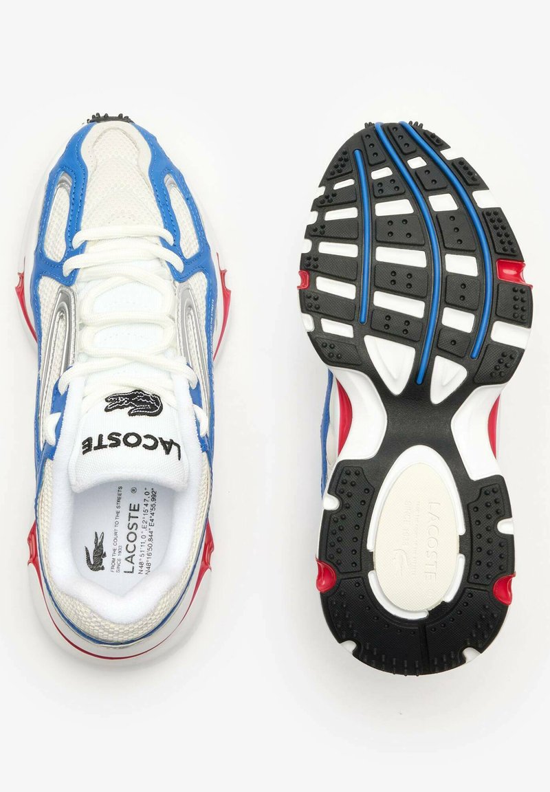 Baskets Lacoste avec une tige en mesh blanc agrémentée d'accents bleus et argentés, détails rouges sur la semelle et une semelle extérieure noire texturée.