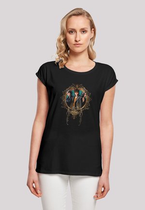 Black t-shirt with rolled sleeves featuring a graphic print of three characters framed in ornate gold detailing. Smooth cotton texture.
