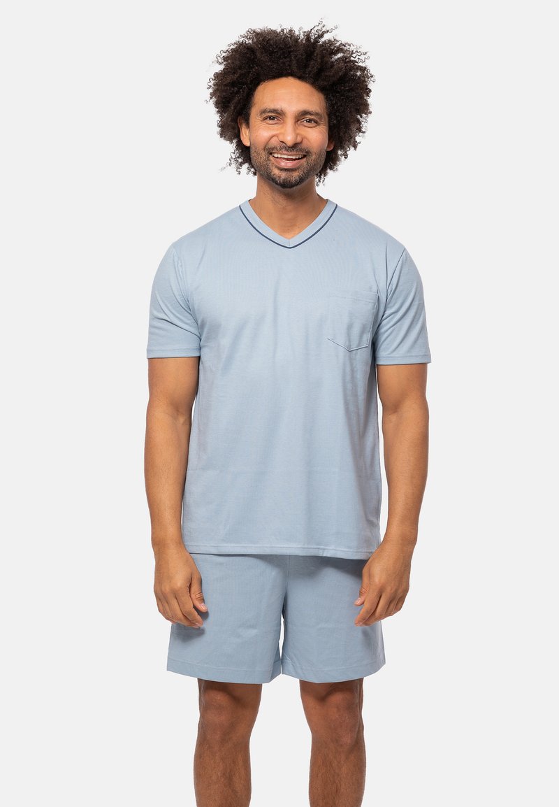 Ljusblått bomullsloungewear-set bestående av en T-shirt med kort ärm och V-ringning samt en bröstficka, tillsammans med matchande shorts. Slät textur och avslappnad passform.