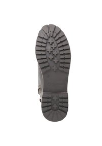 Rubberen zool met diep profiel en kruisvormige noppen, bevestigd aan een bruine leren bovenkant met zijdetails en vetersluitingen.