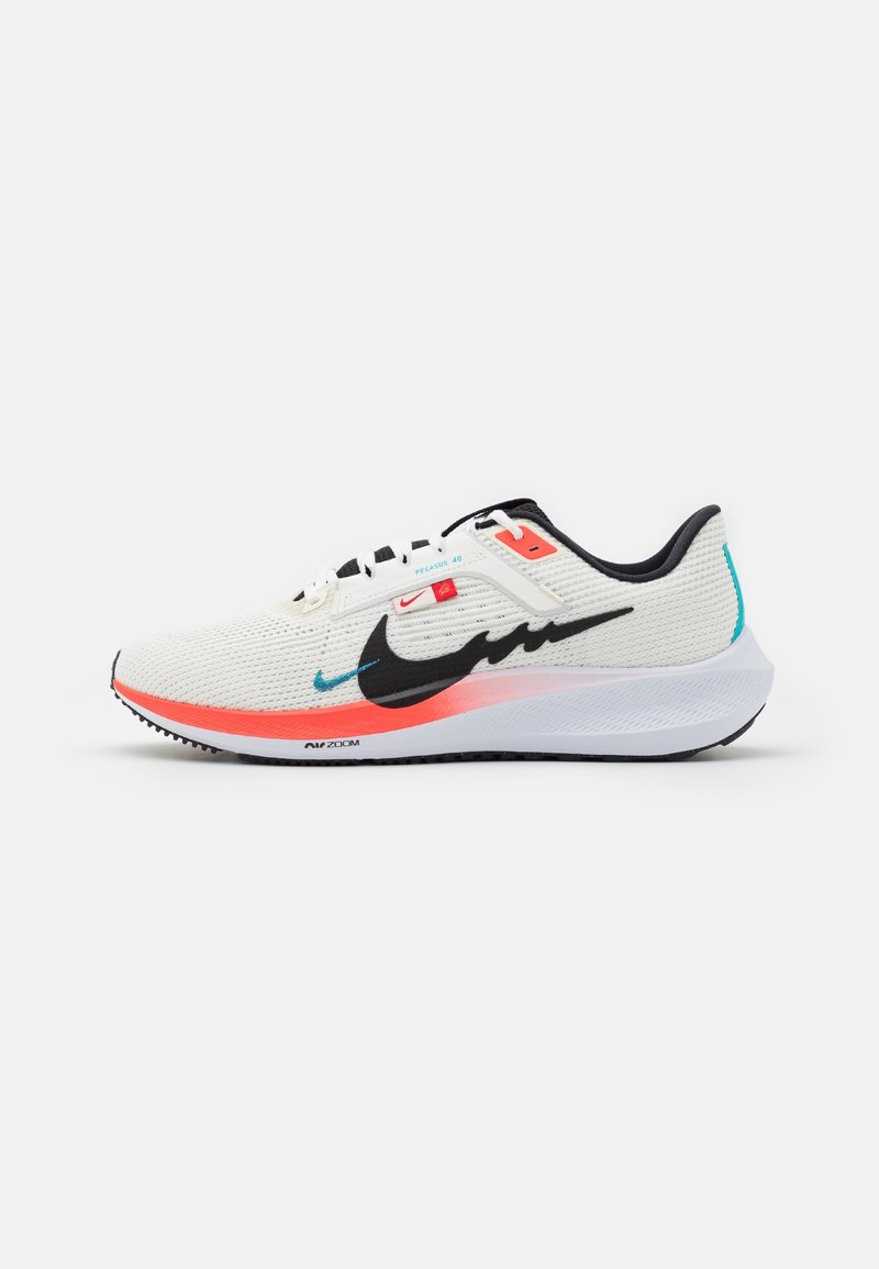Chaussure de course blanche avec virgule Nike noire, accents orange, détails turquoise, tige en mesh blanc et semelle épaisse blanche.