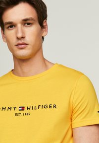 Tommy Hilfiger TOMMY LOGO TEE - Camiseta estampada - eureka yellow