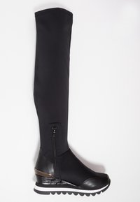 Bottes longues noires au design épuré, fabriquées en matériau doux. Dotées d'une fermeture éclair sur le côté, d'un accent métallique et d'une semelle compensée avec un fond texturé.