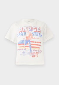 Biely bavlnený tričko s grafickým potlačou gitaristu, textom "Bruce Springsteen" a pozadím americkej vlajky v červenej a modrej.