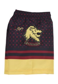 Jupe aux couleurs Gryffindor rouge et jaune avec un motif de lion, des étoiles et une taille élastique, fabriquée en tissu lisse.