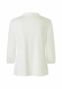 Witte, lange mouwen top met een zachte textuur, voorzien van een rechte onderrand en verzamelde mouwmanchetten. Eenvoudig ontwerp, geen patronen of accenten.