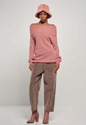 Pink off-shoulder sweater with ribbed neckline, paired with brown corduroy wide-leg trousers and pink heeled ankle boots. Wool felt bucket hat.