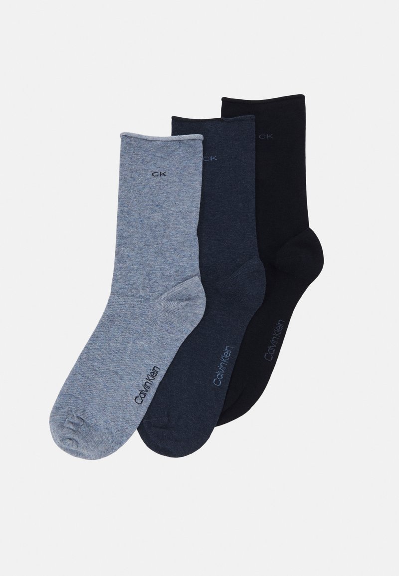 Trīs zeķu pāri: gaiši pelēkas, tumši pelēkas un melnas. Auduma tekstūra ir gluda ar maigu heathered rakstu. Calvin Klein logo ir redzams.