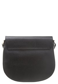 Musta nahkainen crossbody-laukku, jossa on jämäkkä, pyöreä muoto, litteä läppäsuljin ja minimalistinen muotoilu. Varustettu yhdellä säädettävällä hihnalla.