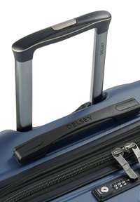 Blauer strukturierter Koffer mit einem schwarzen Griff und Reißverschluss, ausgestattet mit einem integrierten Zahlenschloss. Der Markenname "DELSY" ist am Griff sichtbar.