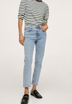 Light blue straight-leg jeans with a high waist, paired with a long-sleeve, cream-and-navy striped shirt and black loafers.