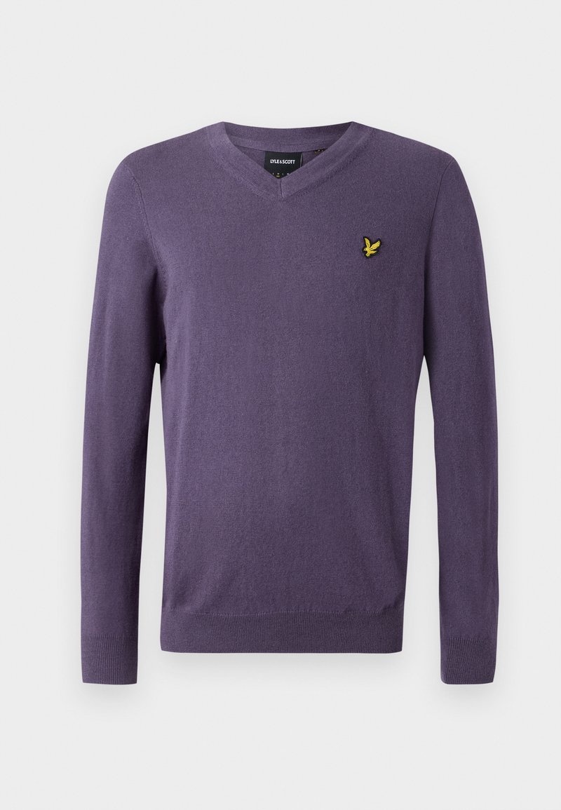 Fioletowy sweter z dekoltem w serek, wykonany z miękkiego materiału, z długimi rękawami i małym złotym logo ptaka na lewej piersi.