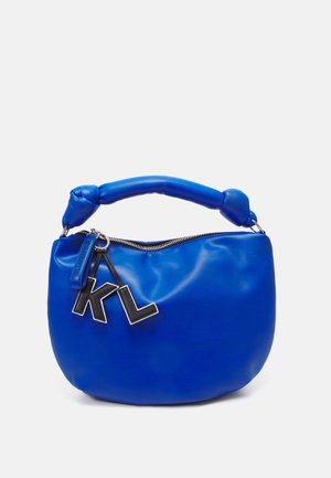 Blå läderhandväska med rundad form, med en knuten handtag, silverfärgade detaljer och "KL" logocharmar på en dragkedjestängning.