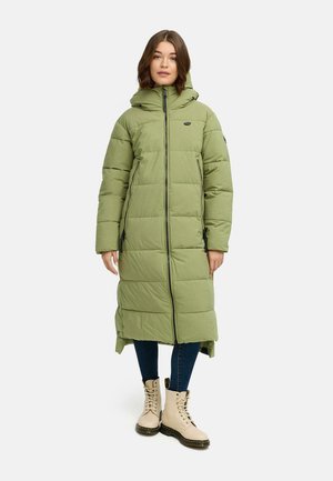 Lang, polstret frakke i lys grøn med lynlås foran, hætte og sidelommer. Matcher med lysebrune snørebåndsstøvler og mørke jeans.