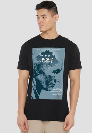 Black cotton T-shirt featuring a graphic print of a blue and white design with the text "THE INNER LIGHT" and related credits.