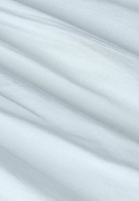 Tissu blanc doux avec des plis délicats et une surface lisse, légèrement texturée.