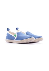 Zapatillas de lona azul de tipo slip-on con una suela de goma blanca, presentan un acento verde y un lazo en el talón para facilitar el calzado.