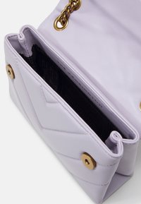 Fialová kožená kabelka s prošívaným designem, zlatými kovovými doplňky a řetízkovým popruhem. Otevřený pohled ukazuje jednu přihrádku s podšívkou.