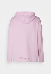 Maglione con cappuccio rosa a maniche lunghe, realizzato in tessuto morbido. Presenta un logo nero in basso a sinistra e un design semplice.