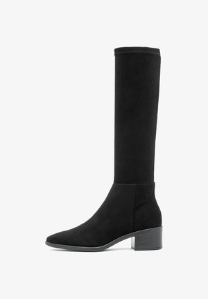 Czarny zamszowy botek do połowy łydki z niskim, stosunkowo szerokim obcasem i okrągłym czubkiem, przedstawiony w profilu bocznym na białym tle.