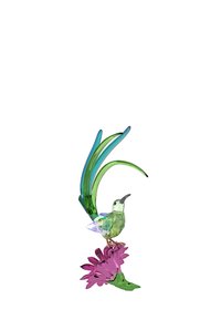 Colibrí de cristal colorido posado sobre una flor rosa, con acentos verdes y plumas de cola alargadas y coloridas. Cuerpo transparente y facetado.