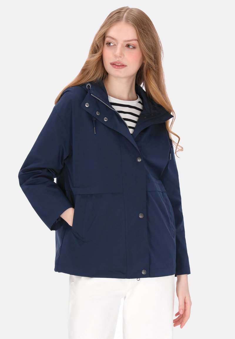 Granatowa wodoodporna kurtka z zamkiem z przodu, dwoma dużymi kieszeniami, kapturem ze sznurkiem oraz luźniejszym krojem. Pod spodem widoczna pasiasta koszula.