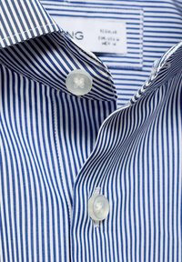 Blauw en witte gestreepte overhemdd met een reguliere kraag, twee parelknopen en een gladde stoftextuur. Label zichtbaar binnenin de kraag.