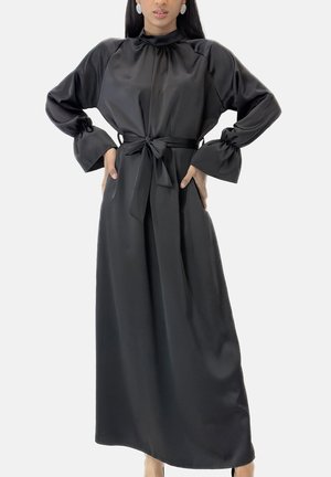 Abito lungo in raso nero con collo alto, maniche lunghe a sbuffo e cintura annodata in vita, caratterizzato da una texture liscia e una silhouette elegante.