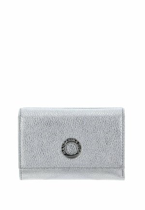 Portefeuille en cuir argenté à finition texturée, avec un logo métallique circulaire en accent sur le devant. Forme compacte et rectangulaire avec une fermeture à rabat.