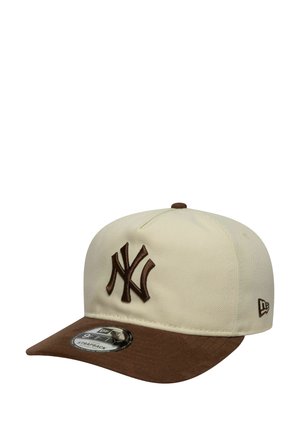 Gorra beige y marrón con un logo NY bordado en marrón en la parte frontal y una pegatina en la visera marrón que muestra los detalles de la correa "9FIFTY".
